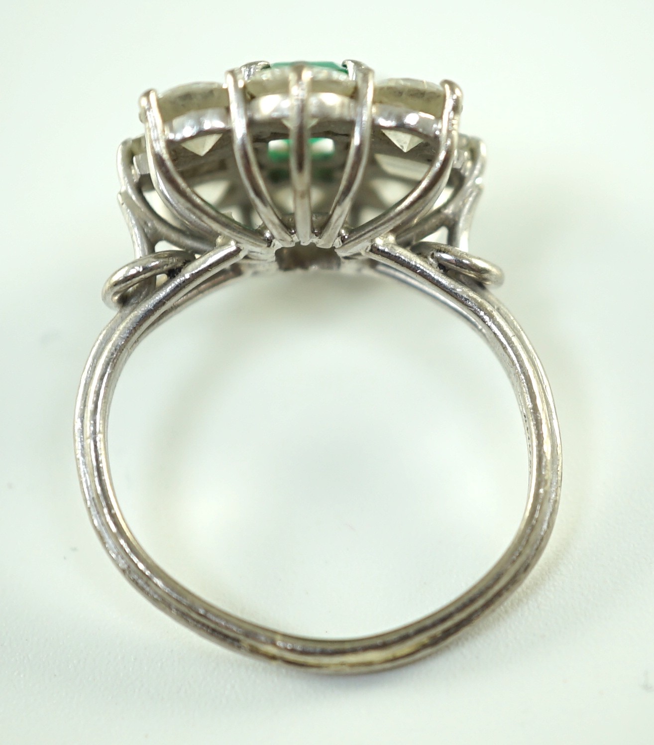 A mid 20th century 18kt white gold, single stone emerald and round and baguette cut diamond set cluster ring